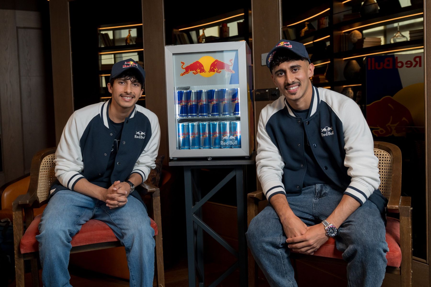 The brothers seated either side of a Red Bull fridge